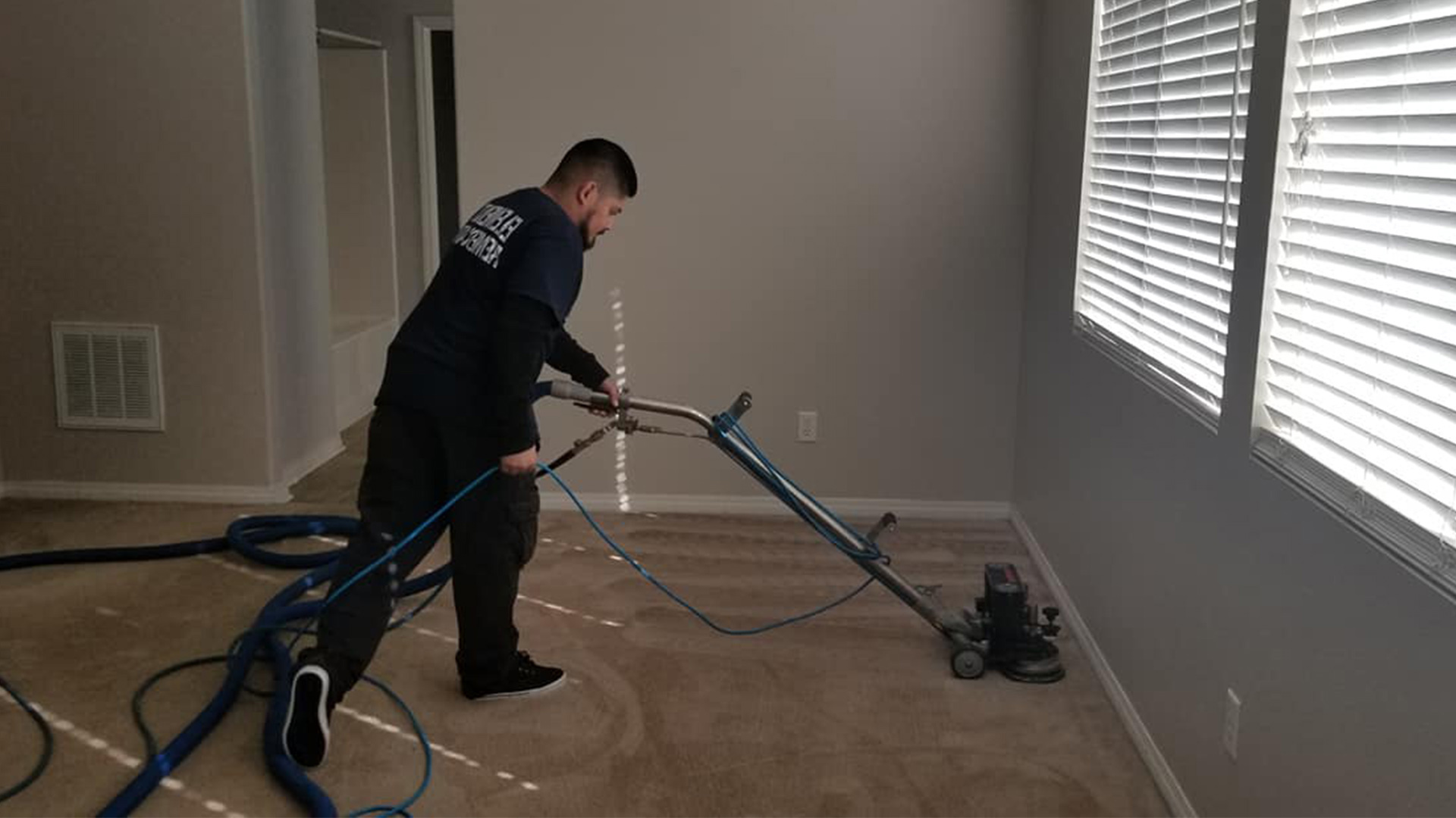 contractor drying carpet floor after water damage at residential property interiors